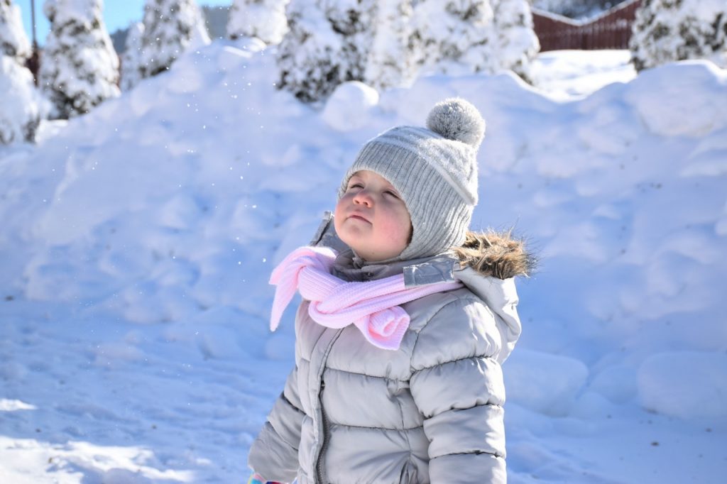 child putting on coat